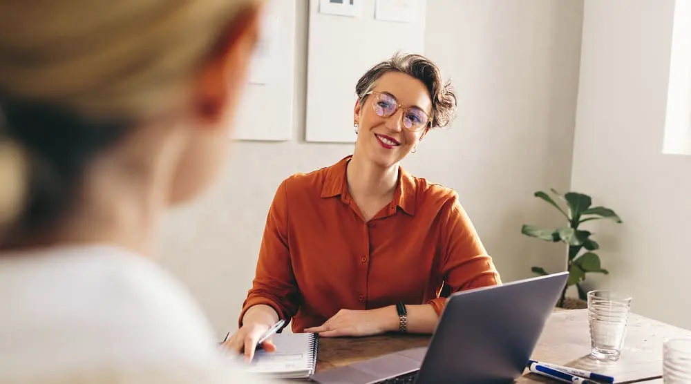 Professional woman at desk with open laptop.