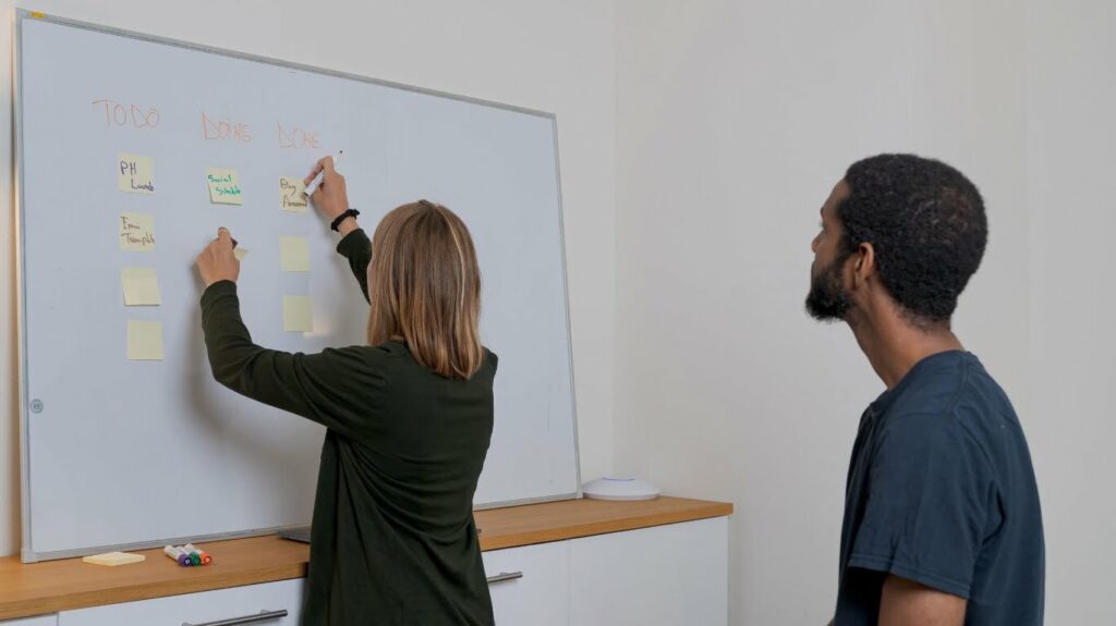 Two educators planning on a whiteboard.