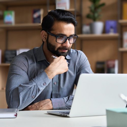 YoungSeriousIndianProfessionalBusinessManFocusedEthnicMaleStudent